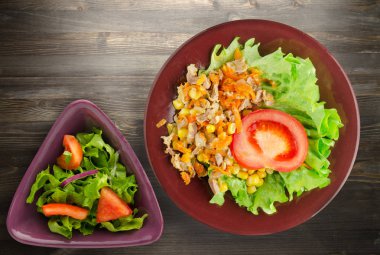 tavuk mideleri havuç ve Mısır ve bir tabak salataya salata. ahşap arka plan üzerinde Sebzeli tavuk salatası