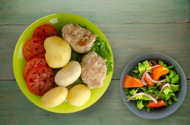  göğsü bir tabak patates ile. göğsü ahşap arka plan üzerinde patates ile