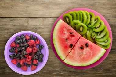 karpuz ve bir tabak ya da ahşap bir arka plan üzerinde dilimlenmiş kivi