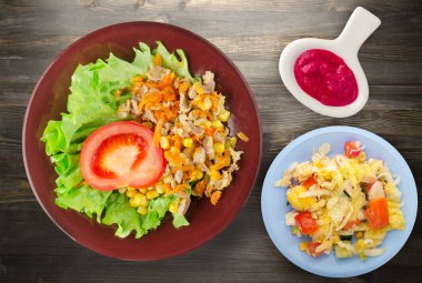 tavuk mideleri havuç ve Mısır ve bir tabak salataya salata. ahşap arka plan üzerinde Sebzeli tavuk salatası