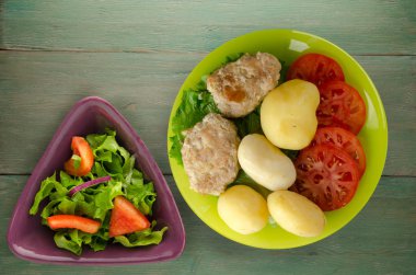  göğsü bir tabak patates ile. göğsü ahşap arka plan üzerinde patates ile