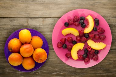 Diyet, sağlıklı gıda. böğürtlen, ahududu, nektarin bir plaka üzerinde bir tabakta. Ahşap arka plan üzerinde Vejetaryen yiyecekler.