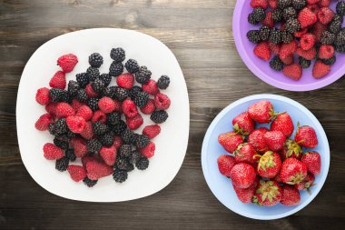 böğürtlen ve ahududu bir plaka üzerinde. böğürtlen ve ahududu ahşap arka plan üzerinde. Vejetaryen gıda .
