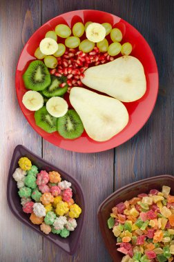 ahşap arka plan üzerinde meyve karışımı (armut, kivi, üzüm, muz, nar). meyve bir plaka üzerinde