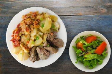  patates ve haşlanmış domates ile kızarmış karaciğer. ahşap arka plan üzerinde plaka üzerinde kızarmış karaciğer