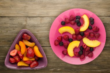 Diyet, sağlıklı gıda. böğürtlen, ahududu, nektarin bir plaka üzerinde bir tabakta. Ahşap arka plan üzerinde Vejetaryen yiyecekler.
