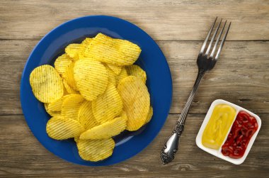 bir tabak patates cipsi. ahşap arka plan üzerinde fiş .