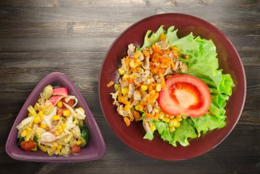 tavuk mideleri havuç ve Mısır ve bir tabak salataya salata. ahşap arka plan üzerinde Sebzeli tavuk salatası