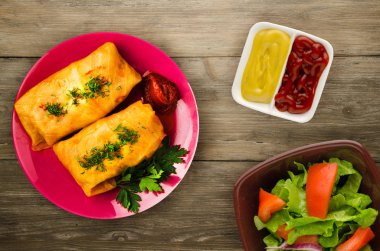 lahana bir tabak içinde alır. lahana bir ahşap arka plan üzerinde rulo. et lahana Üstten Görünüm.