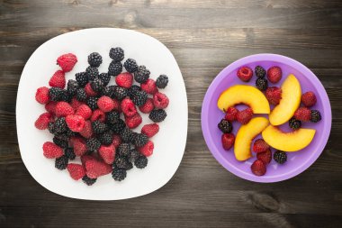 böğürtlen ve ahududu bir plaka üzerinde. böğürtlen ve ahududu ahşap arka plan üzerinde. Vejetaryen gıda .