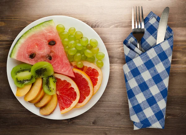 sliced fruit on a wooden background. sliced fruit on a plate