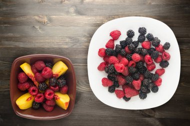 böğürtlen ve ahududu bir plaka üzerinde. böğürtlen ve ahududu ahşap arka plan üzerinde. Vejetaryen gıda .