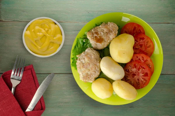  göğsü bir tabak patates ile. göğsü ahşap arka plan üzerinde patates ile