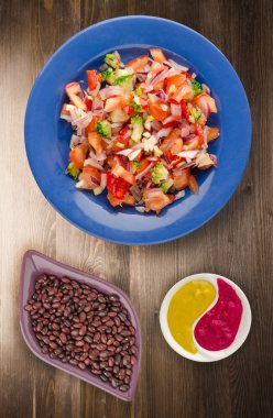 vegan gıda. salata bir tabakta sebze (biber, domates, soğan, brokoli) üzerinden. vegan salata ahşap arka plan üzerinde