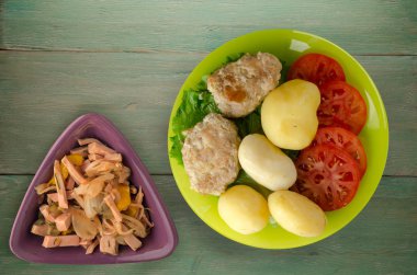  göğsü bir tabak patates ile. göğsü ahşap arka plan üzerinde patates ile