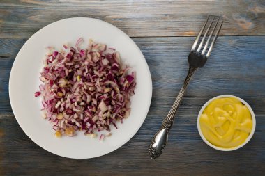 ahşap arka plan üzerinde kırmızı soğan. bir plaka üzerinde doğranmış kırmızı soğan