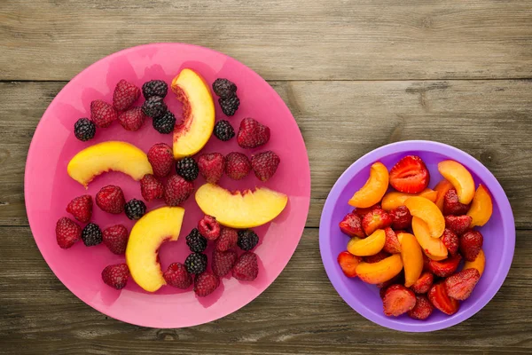 Diyet, sağlıklı gıda. böğürtlen, ahududu, nektarin bir plaka üzerinde bir tabakta. Ahşap arka plan üzerinde Vejetaryen yiyecekler.