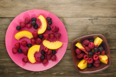 Diyet, sağlıklı gıda. böğürtlen, ahududu, nektarin bir plaka üzerinde bir tabakta. Ahşap arka plan üzerinde Vejetaryen yiyecekler.