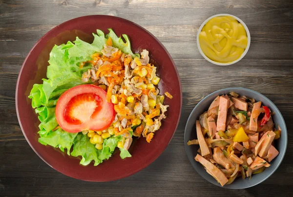 Salad with chicken stomachs with carrots and corn and salad on a plate. chicken salad with vegetables on a wooden background — Stock Image Salad Chicken Stomachs Carrots Corn Salad Plate Chicken Salad Vegetables Stock Picture