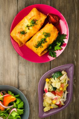 lahana bir tabak içinde alır. lahana bir ahşap arka plan üzerinde rulo. et lahana Üstten Görünüm.