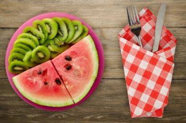 karpuz ve bir tabak ya da ahşap bir arka plan üzerinde dilimlenmiş kivi