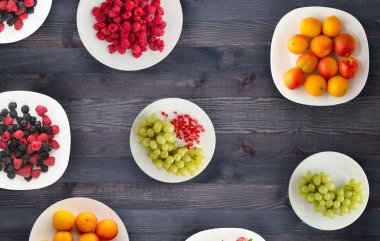 meyve bir plaka üzerinde. Vejetaryen gıda ahşap arka plan üzerinde. vegan gıda üstten görünüm .