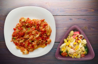 Haşlanmış domates soğan bir plaka üzerinde bir ahşap arka plan ile. haşlanmış domates soğan en iyi manzaralı. Vejetaryen Gıda