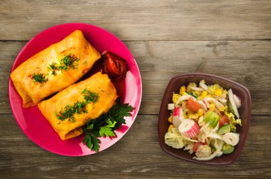 lahana bir tabak içinde alır. lahana bir ahşap arka plan üzerinde rulo. et lahana Üstten Görünüm.