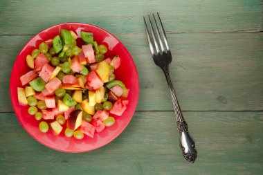 ahşap arka plan üzerinde meyve salatası. Vejetaryen salata meyve bir plaka üzerinde