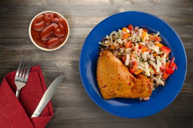 ahşap arka plan üzerinde sebze salatası ile tavuk kanadı. tavuk kanadı bir tabakta sebze ile.