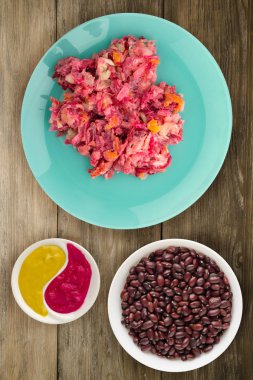 Ringa altında bir plaka üzerinde bir kürk manto. Bir kürk manto ahşap arka plan üzerinde altında ringa balığı. Ringa balığı, kırmızı pancar, havuç, mayonez ve soğan salata .