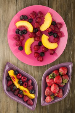 Diyet, sağlıklı gıda. böğürtlen, ahududu, nektarin bir plaka üzerinde bir tabakta. Ahşap arka plan üzerinde Vejetaryen yiyecekler.