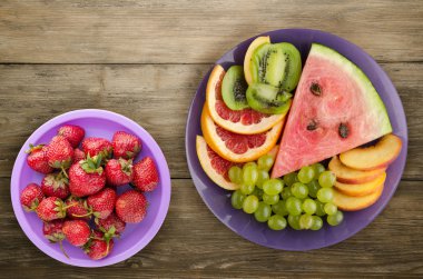 meyve bir ahşap arka plan üzerine dilimlenmiş. meyve bir tabağa dilimlenmiş