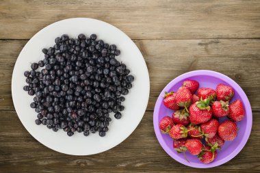 ahşap arka plan üzerinde bir plaka üzerinde yaban mersini. meyve diyeti. vegan gıda .