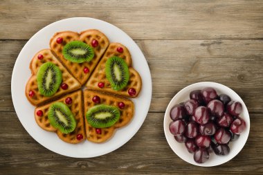 gofret kivi ve kızılcık ahşap arka plan üzerinde. Waffle plaka üstten görünüm üzerinde