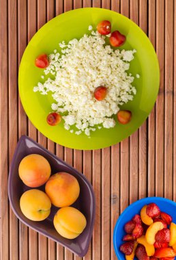 Kiraz ahşap arka plan üzerinde bir plaka üzerinde süzme peynir. sağlıklı gıda. lezzetli kahvaltı .