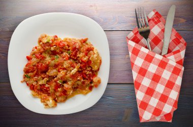 Haşlanmış domates soğan bir plaka üzerinde bir ahşap arka plan ile. haşlanmış domates soğan en iyi manzaralı. Vejetaryen Gıda