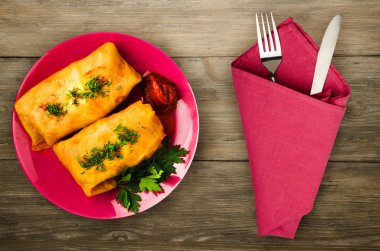 lahana bir tabak içinde alır. lahana bir ahşap arka plan üzerinde rulo. et lahana Üstten Görünüm.