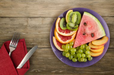 meyve bir ahşap arka plan üzerine dilimlenmiş. meyve bir tabağa dilimlenmiş