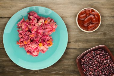 Ringa altında bir plaka üzerinde bir kürk manto. Bir kürk manto ahşap arka plan üzerinde altında ringa balığı. Ringa balığı, kırmızı pancar, havuç, mayonez ve soğan salata .