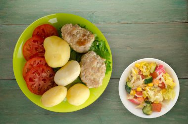  göğsü bir tabak patates ile. göğsü ahşap arka plan üzerinde patates ile