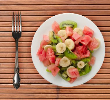 sağlıklı taze meyve salatası ahşap zemin üzerine tabak .