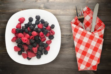 böğürtlen ve ahududu bir plaka üzerinde. böğürtlen ve ahududu ahşap arka plan üzerinde. Vejetaryen gıda .