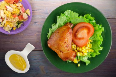 salata, Mısır ve domates bir tabakta tavuk kanadı. rustik bir arka plan üzerine Sebzeli tavuk kanadı