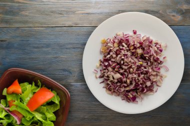 ahşap arka plan üzerinde kırmızı soğan. bir plaka üzerinde doğranmış kırmızı soğan