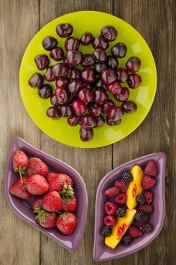 Berry Kiraz ahşap arka plan üzerinde bir tabakta. meyve diyeti. vegan gıda