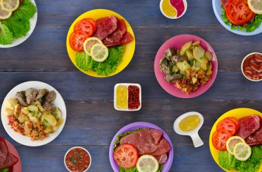 bir tabak üzerinde et yemekleri. bir tabak salata. masada yiyecek bolluk. 