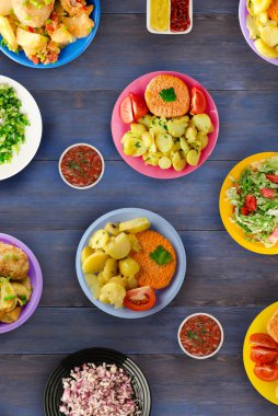  Baharatlı bir marinat pişmiş lezzetli baharatlı kızarmış domuz pirzola haşlanmış patates, salata ve soslar ile servis edilir. Ahşap masada bir plaka üzerinde cutlets 