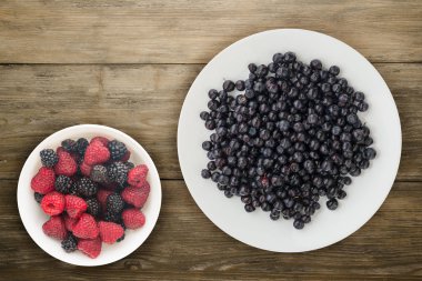 ahşap arka plan üzerinde bir plaka üzerinde yaban mersini. meyve diyeti. vegan