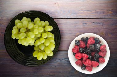 ahşap arka plan üzerinde üzüm. bir plaka üzerinde üzüm